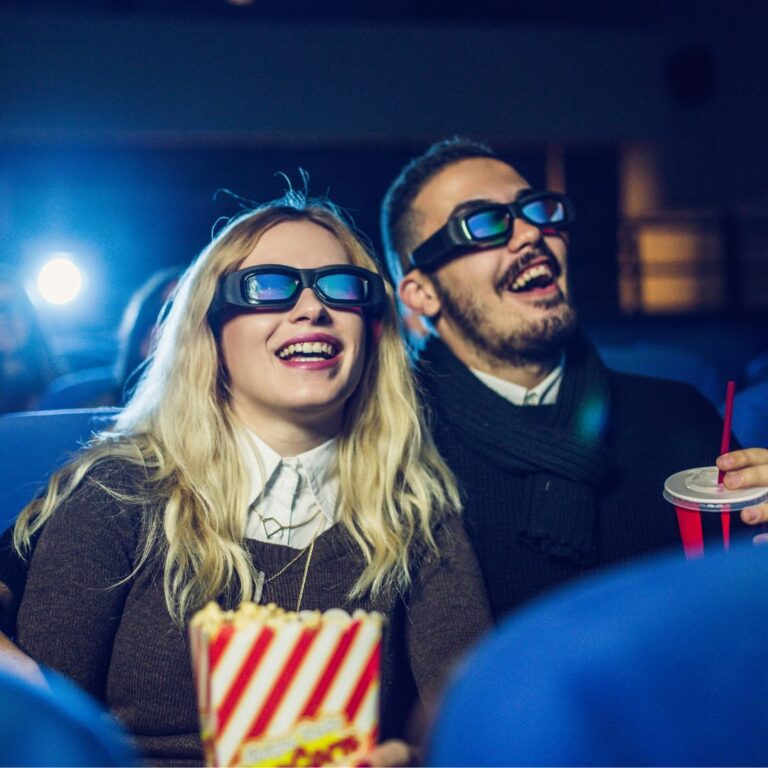 Man and woman with 3D glasses in movie theatre